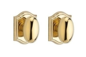 The Baldwin Reserve Ellipse Knob with Traditional Arch Rosette in Lifetime Polished Brass finish.