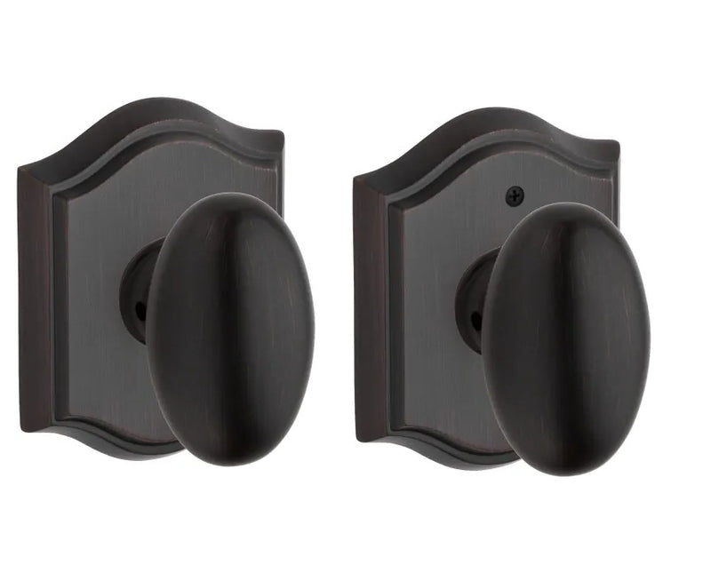 The Baldwin Reserve Ellipse Knob with Traditional Arch Rosette in Venetian Bronze finish.