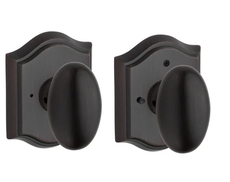 The Baldwin Reserve Ellipse Knob with Traditional Arch Rosette in Venetian Bronze finish.