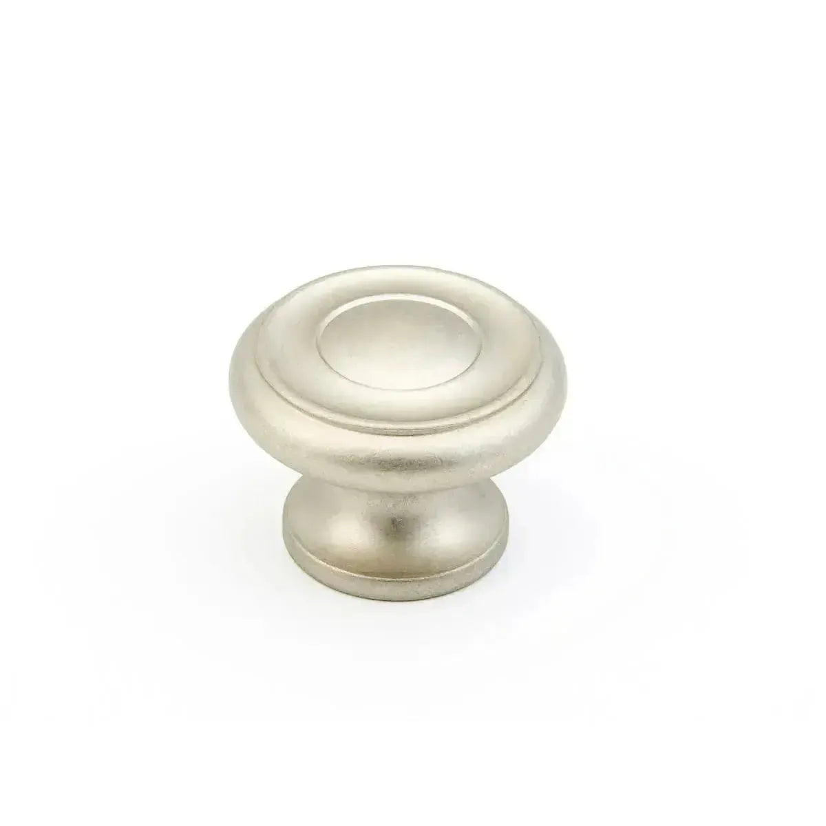 The Schaub Traditional Stepped Round Cabinet Knob in Distressed Nickel finish.