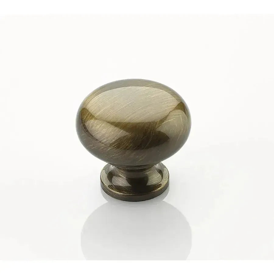 The Schaub Traditional Round Cabinet Knob in Antique Brass finish.