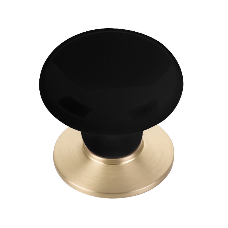 The Emtek Ebony Porcelain Cabinet Knob in Satin Brass finish